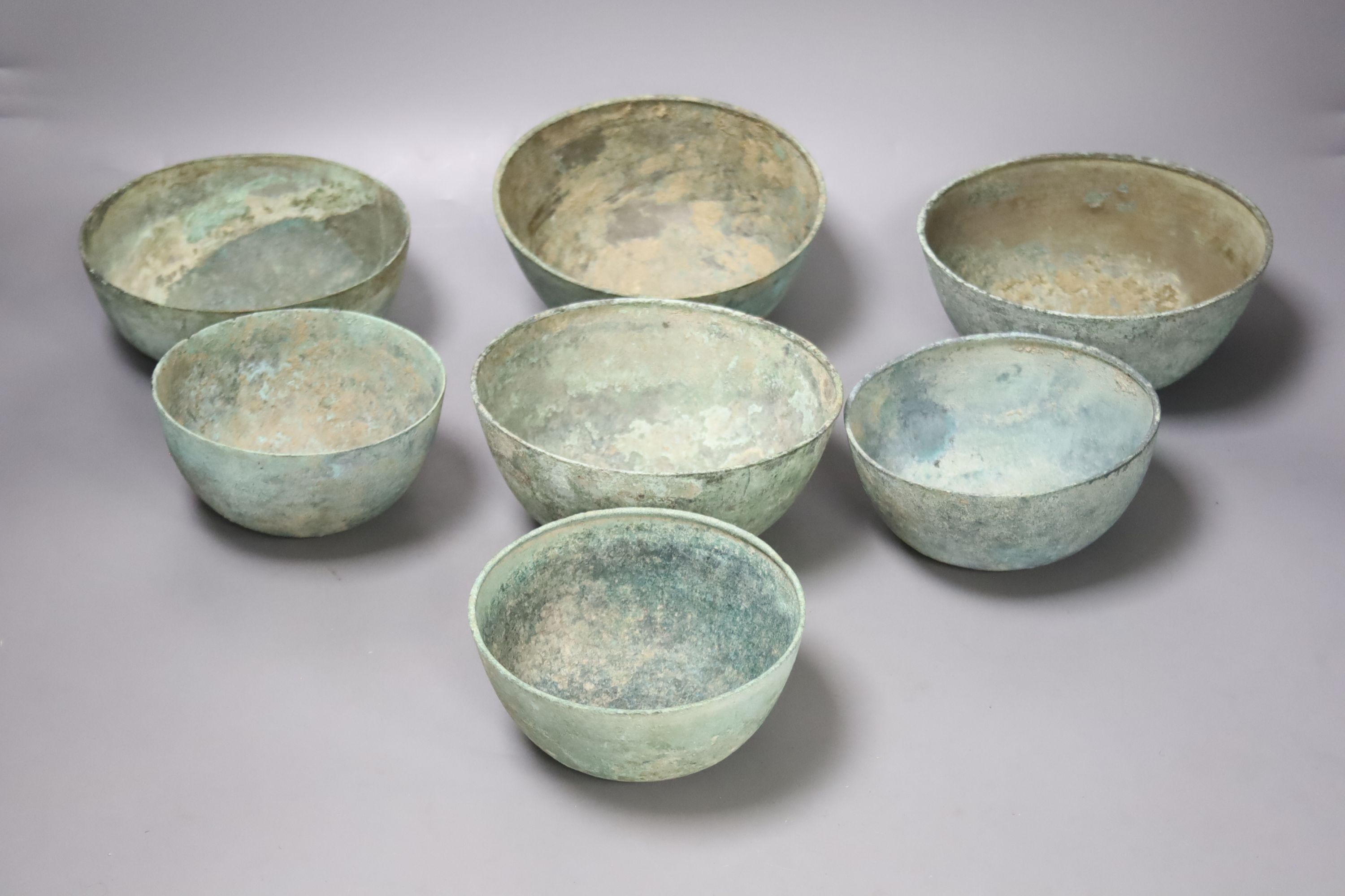 Seven Cambodian bronze ritual offering or water bowls, Khmer, 12th/13th century